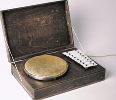 an old record player in a wooden box with a white frisbee on it