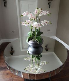 there is a vase with flowers in it on the glass table next to the door