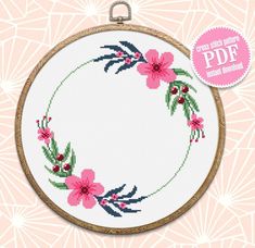 a cross stitch hoop with pink flowers on it