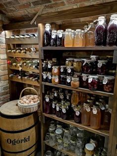 a wooden barrel filled with lots of different types of jars and containers on top of shelves next to a brick wall