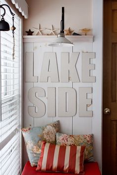 a red bench sitting under a light on top of a wooden sign that says lake side