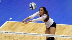 a woman hitting a volleyball over the net