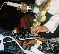 a man playing an electric guitar on top of a table