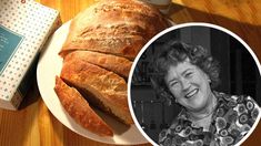 an older woman is smiling next to a loaf of bread