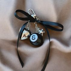 a close up of a keychain on a cloth with a black ribbon around it