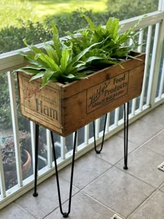 a wooden planter with plants in it on a porch