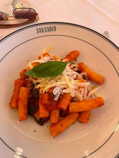 a white plate topped with pasta and cheese