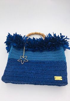 Handmade blue crochet handbag with raffia decor and bamboo handle. Fabric lining inside. Dimensions: 29cm x 32cm x 7cm Brand logo can be moved inside on request. Blue Handheld Bags For Vacation, Handheld Blue Bag For The Beach, Blue Top Handle Straw Bag For Travel, Blue Top Handle Shoulder Bag For Summer, Blue Top Handle Straw Bag For Everyday Use, Blue Handwoven Straw Bag For Beach Season, Handheld Crochet Beach Bag With Handles, Blue Handwoven Summer Beach Bag, Blue Bohemian Crochet Bag With Woven Details