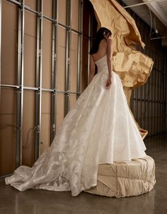 a woman in a wedding dress standing on a mattress