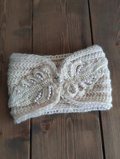 a white knitted headband with an embellishment on the front and side