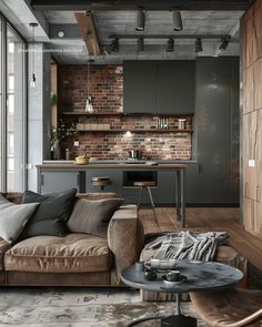 a living room filled with furniture and a brick wall behind the couch is a kitchen