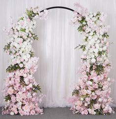 two floral archways with white and pink flowers on the top, one in front of the other