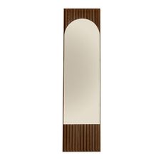 a tall mirror sitting on top of a white wall