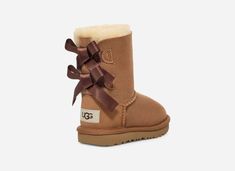 Your little one will adore these UGG® Toddlers' Bailey Bow II Boots with sweet silky bows in classic Brown. Designed for comfort and style, these boots feature a super-soft sheepskin lining and ultra-lightweight outsole for traction and durabilityâ€”perfect for active kiddos.The outsole of this product is either a SugarSole outsole, which is a responsible compound using sugarcane foam that allows us to reduce dependency on fossil fuels by replacing petroleum-based ethylene, or a Treadlite by UGG