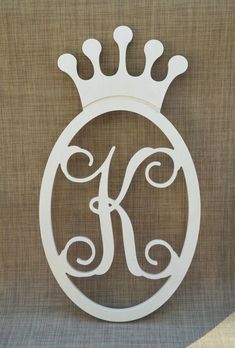 the monogrammed letter k is made from wood and has a crown on top