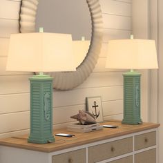 two lamps sitting on top of a dresser next to a mirror