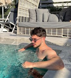 a man is in the pool with sunglasses on