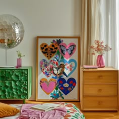 a bedroom with an art work on the wall next to two dressers and a bed