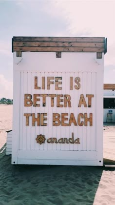 a life is better at the beach sign with words written on it in gold foil