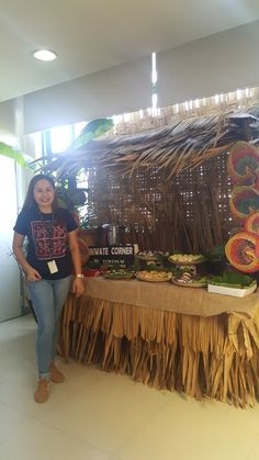 a woman standing in front of a table with food on it and decorations hanging from the ceiling