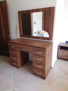 a bedroom with a bed, dresser and mirror on the floor in front of it