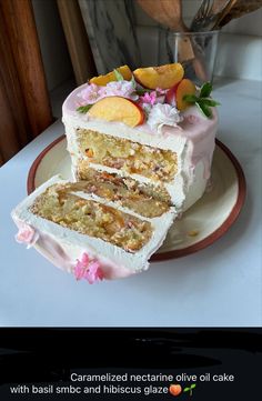 a piece of cake on a plate with flowers and fruit in the top layer is cut into pieces