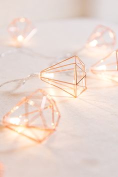 some lights that are on top of a white table and one is shaped like a diamond