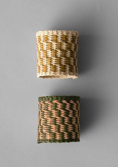 two pieces of woven material sitting on top of a gray surface, one with green and white stripes