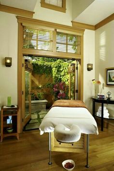 a spa room with an open door leading to the outside area and wooden flooring