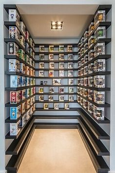 a room filled with lots of books on shelves next to a wall covered in pictures