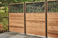 a wooden fence with metal screens on it and flowers in the back ground behind it