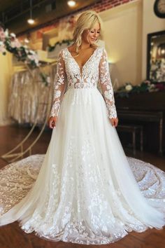 a woman in a white wedding dress standing on a wooden floor with her back to the camera