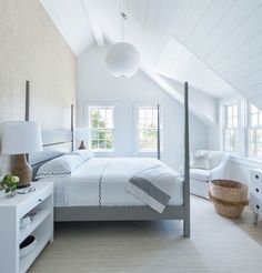 a bedroom with white walls and floors has a large bed