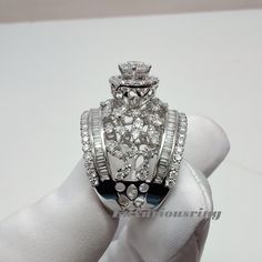 a diamond ring is being held by someone's hand with white gloves on it