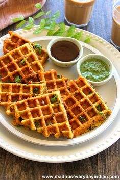 three waffles on a plate with dipping sauce