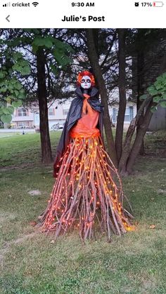 a halloween decoration in the yard with lights on it and a woman dressed as a skeleton