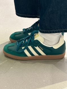 a person wearing green adidas sneakers and blue jeans