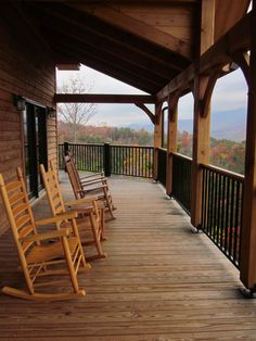 wooden rocking chairs are lined up on the porch