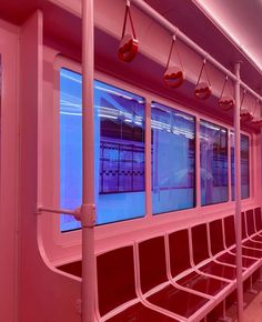 an empty train car with red seats and blue lights on the windows is seen in this image