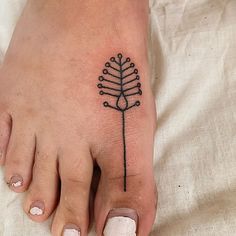 a woman's foot with a small tattoo on the top and bottom of it