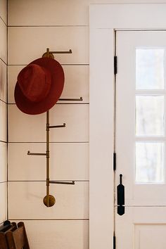 a hat and coat rack on the wall next to a door