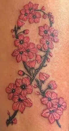 a woman's back with red flowers on her shoulder and the word love written in black ink