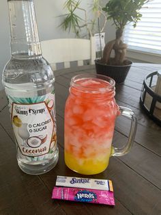 a drink and candy sitting on top of a wooden table next to a bottle of water