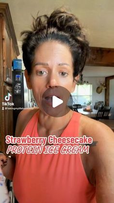 a woman making a funny face while standing in front of a kitchen counter with an ice cream container