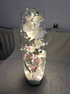 a glass vase filled with white and pink flowers