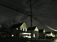 a dark street at night with houses lit up