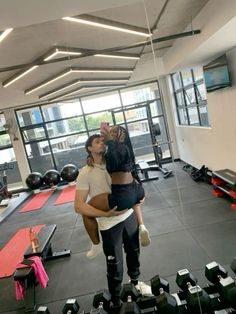 a man holding a woman in the middle of a gym