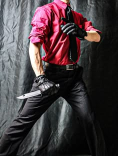 a man in red shirt and black pants holding a knife