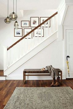 a person sitting on a bench in front of a stair case with pictures above it