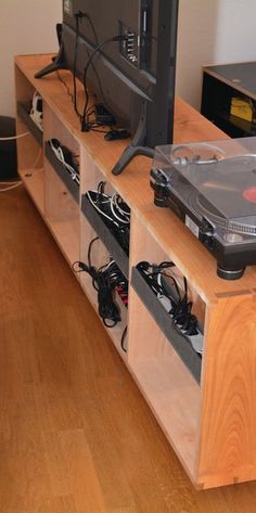 a record player sitting on top of a wooden shelf next to a tv and speakers